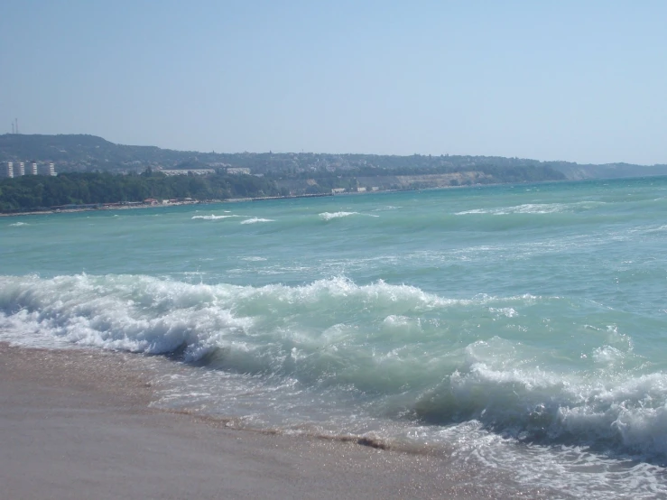 a body of water with wave coming up from the shore