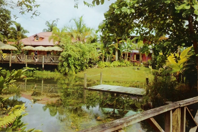 a wooden bridge crosses over a small pond and into a lodge