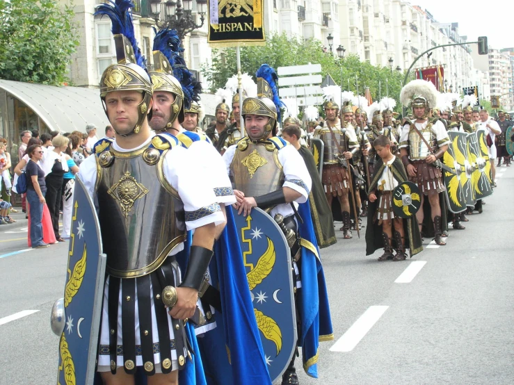 a group of men dressed in armor walking down a road