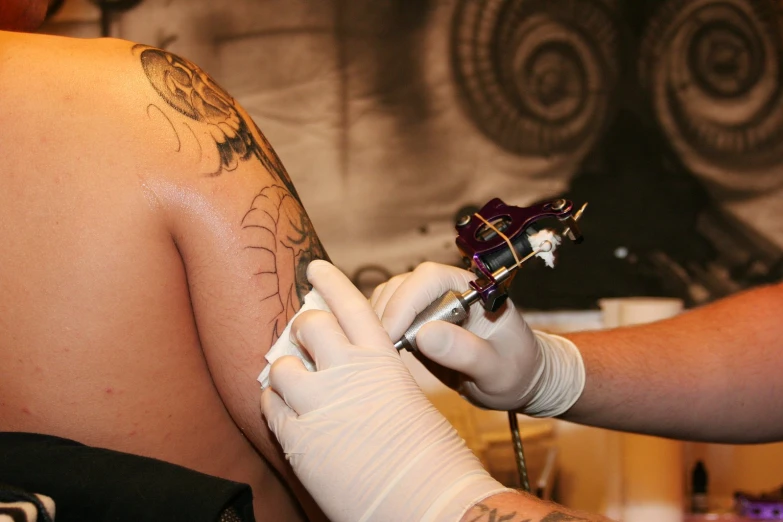 a woman getting her tattoo done at the same time