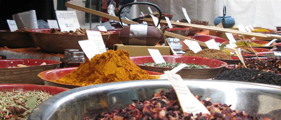 a variety of spices sit in silver bowls