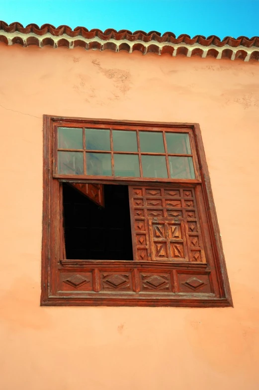 a window with an open frame and decorative wooden trim