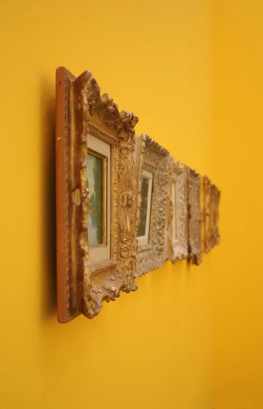 two wall hangings with some gold frames