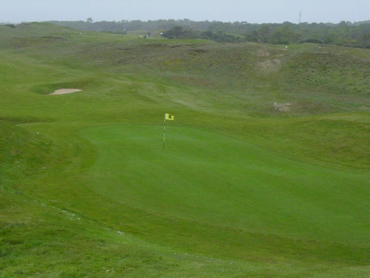 an empty golf green on the side of a hill