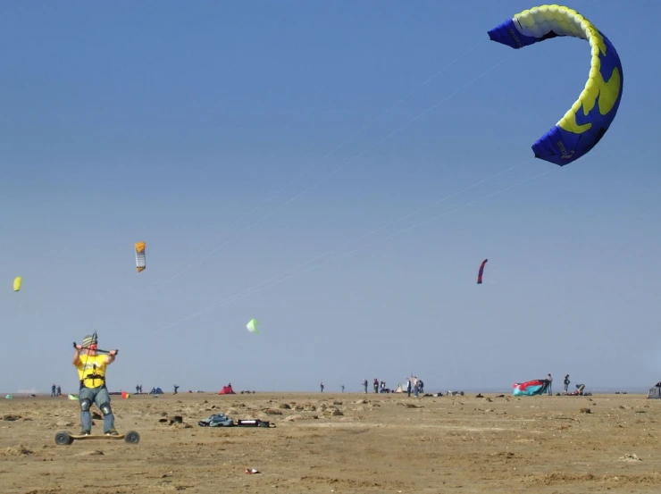 a man standing on a beach while flying two kites