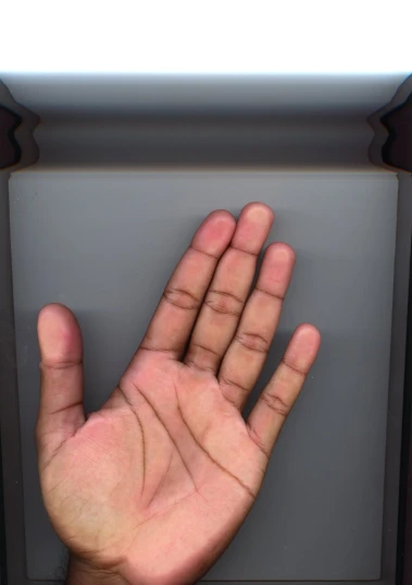 a hand extended in front of a computer screen