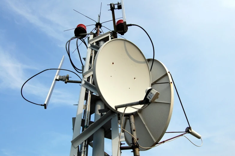 a big satellite dish in the air with the blue sky behind it