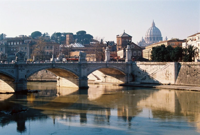 a body of water with some buildings and a bridge