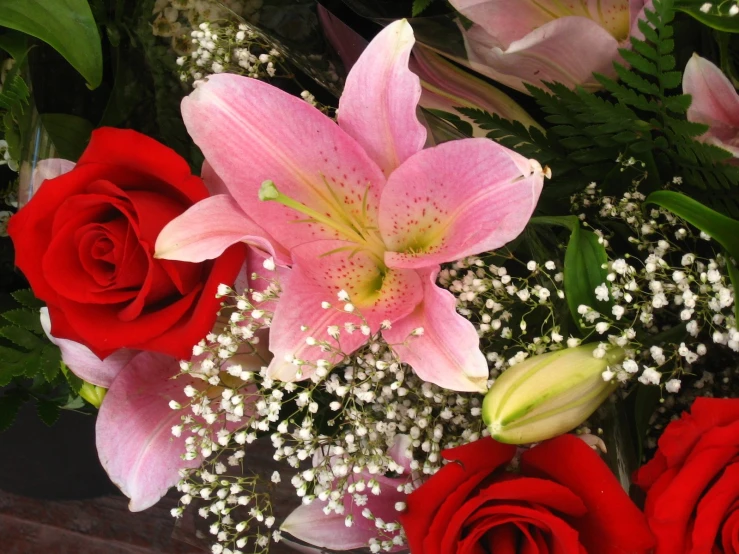 pink and red flowers sit on a glass vase