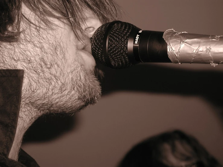 a man who is listening into a microphone