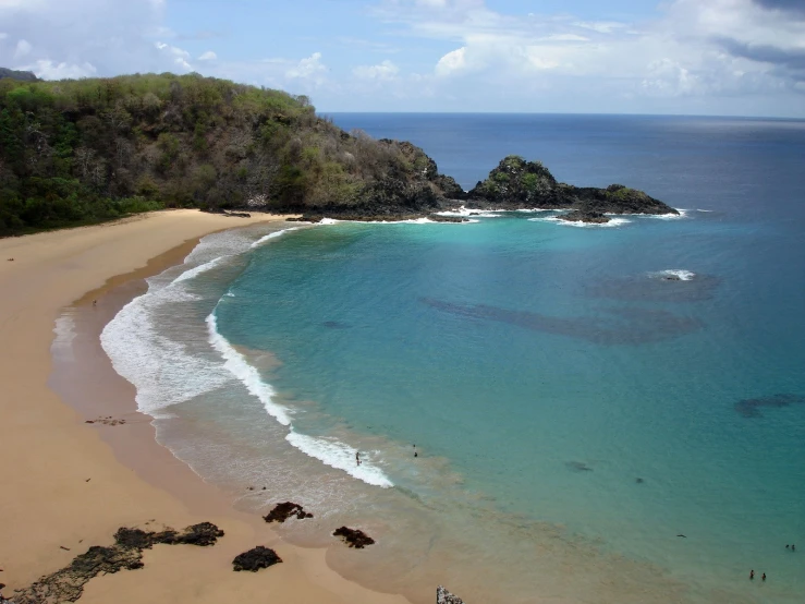 an ocean view showing beach in front of rock formations