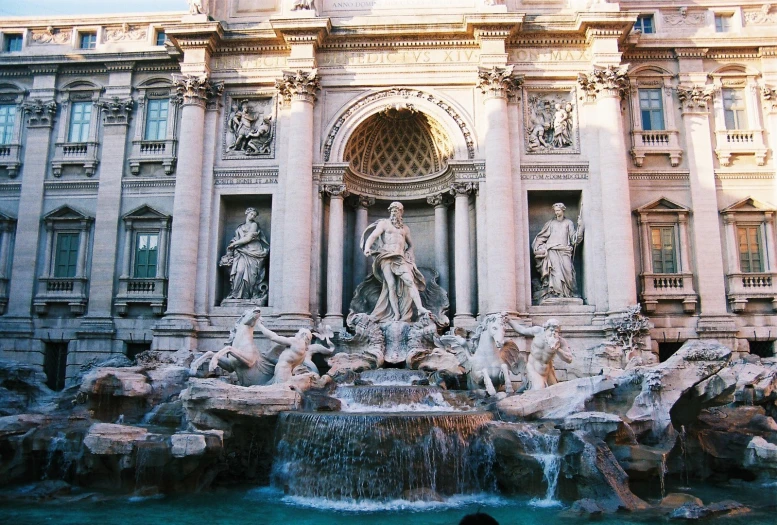 an elegant building features a fountain and statues