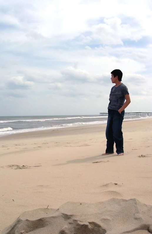 a man standing on the beach looking into the distance