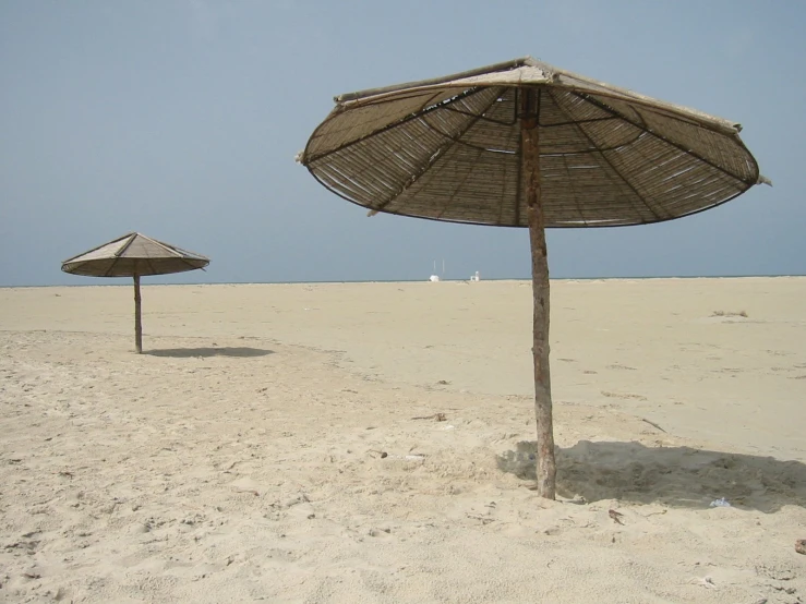 there are three umbrellas in the sand on the beach