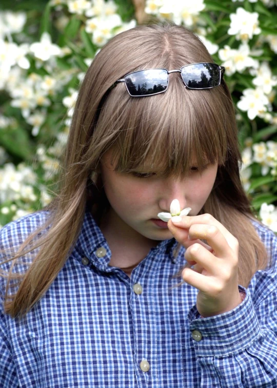  wearing sunglasses chewing on a flower