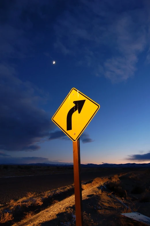 an upside down sign in a desert landscape