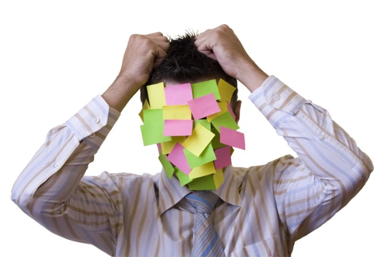 the man is wearing a neck tie and has papers attached to his head