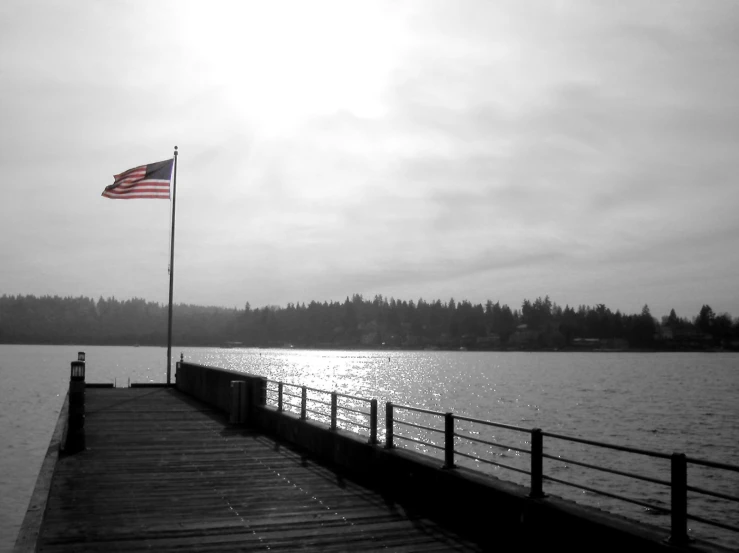 the american flag is fluttering over a boat dock