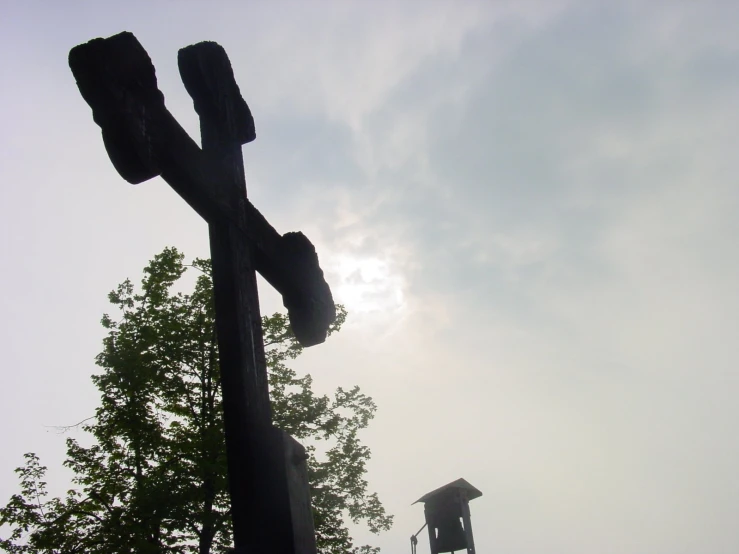 a large wooden pole sitting next to a forest