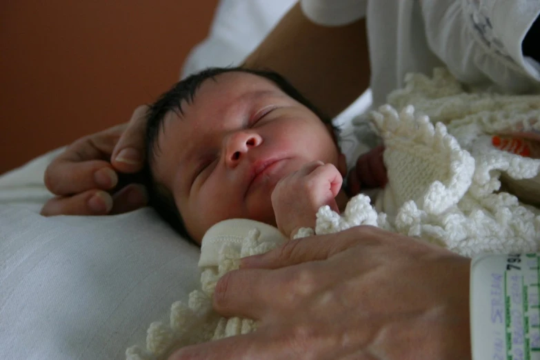 a newborn baby laying in his father's arms