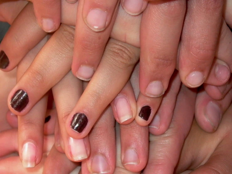 several hands are stacked and all have different manies on their fingertipss