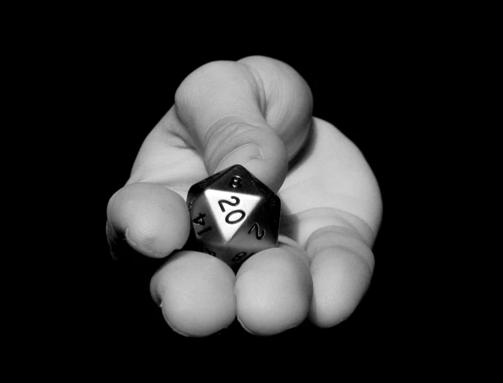 someones hand holding a silver metal d20 dice