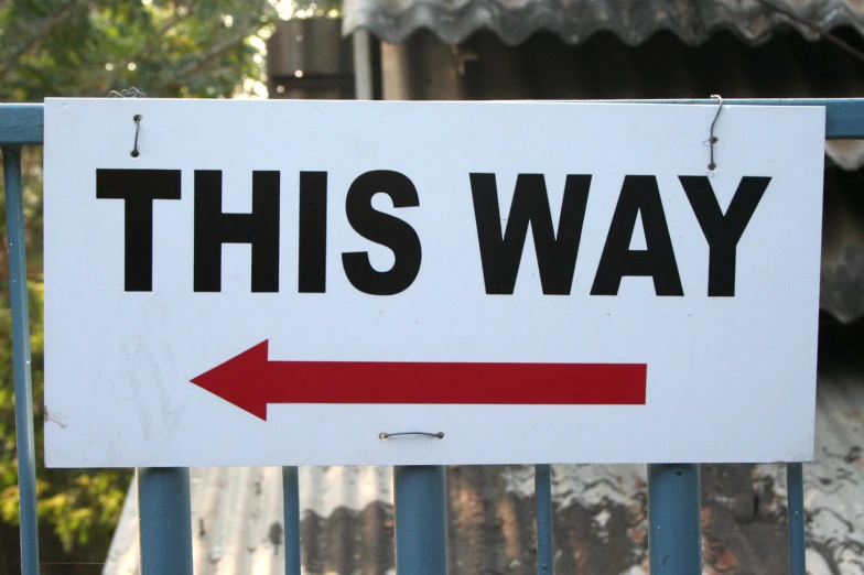 a large white sign with a red arrow pointing the same direction