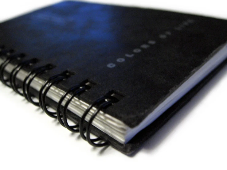 the black and blue book is placed on a white surface