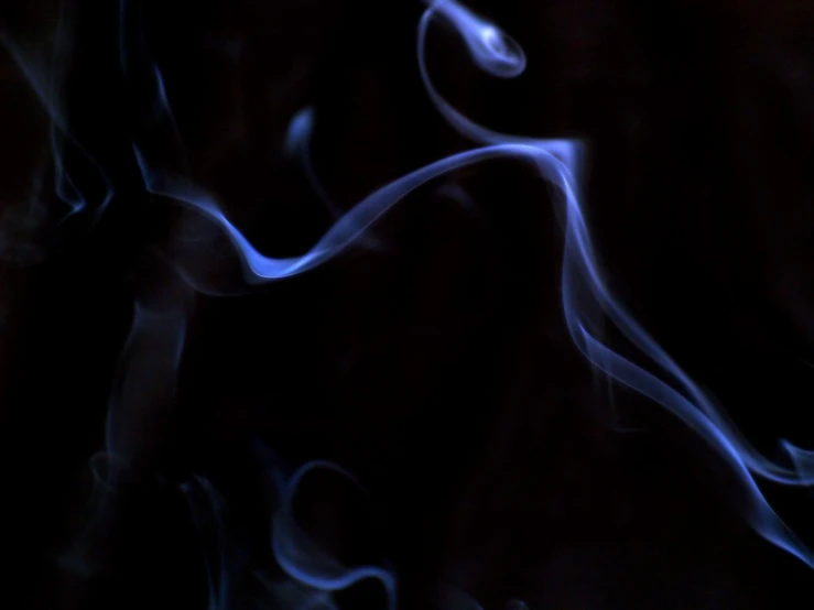 blue smoke is shown in the dark with black background
