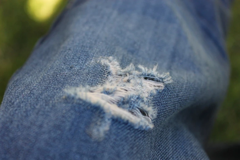 ripped jeans in close up showing holes on the fabric