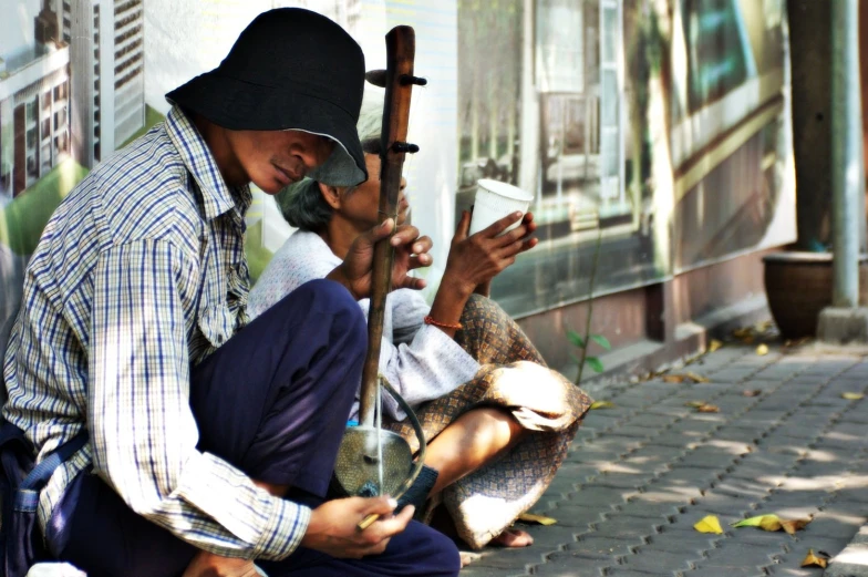 the man is sitting down with his cross and cell phone