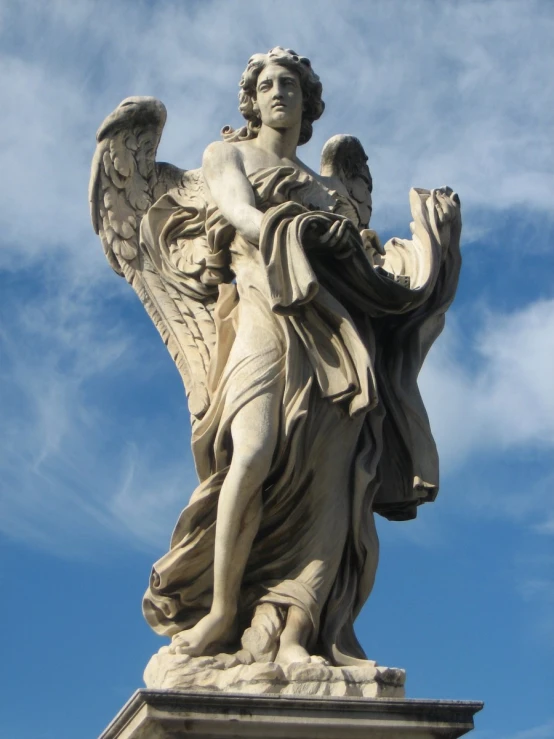 statue in front of a blue sky and clouds