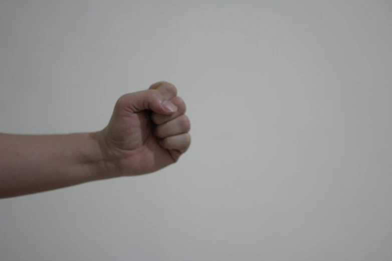 a person holds up their arm and thumb