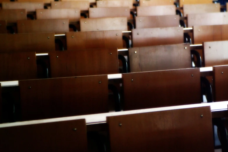 rows of wooden seats are lined up in the empty