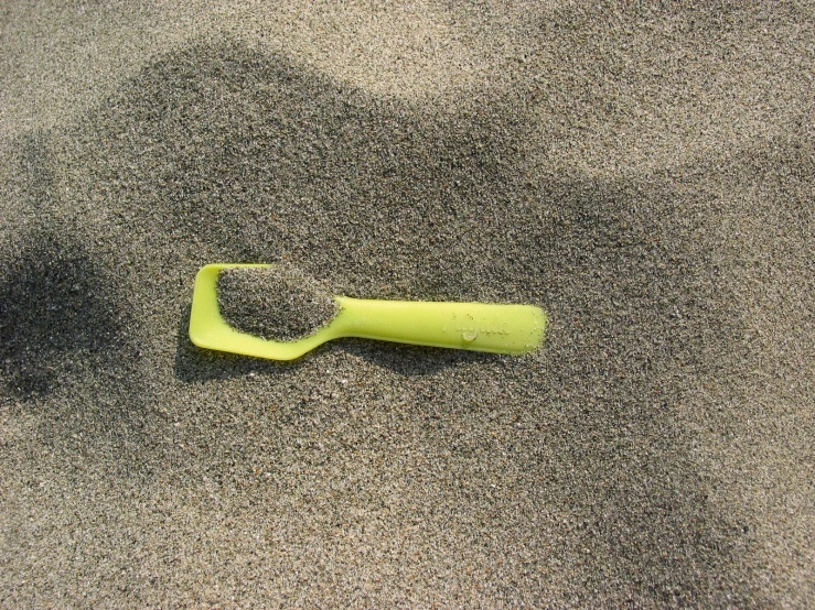 an object is lying on the sand near a bottle