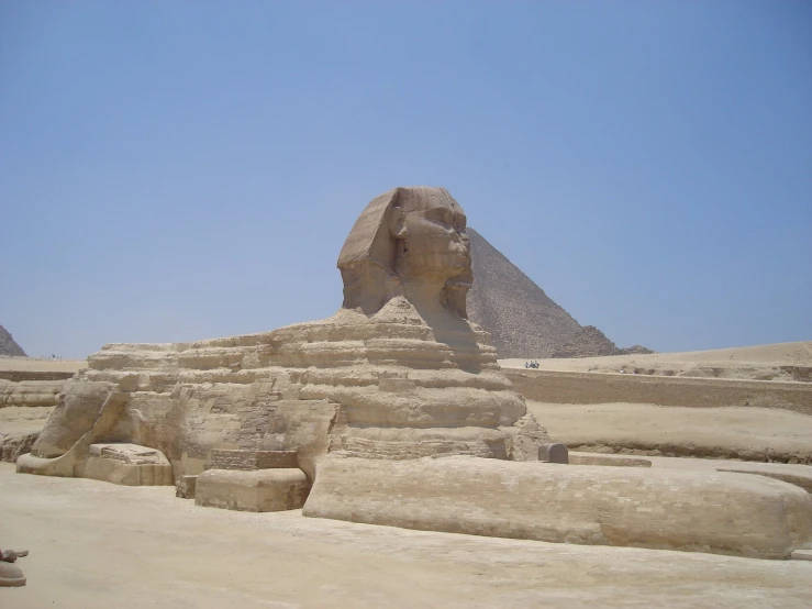 an intricately carved sphinx in front of the pyramids