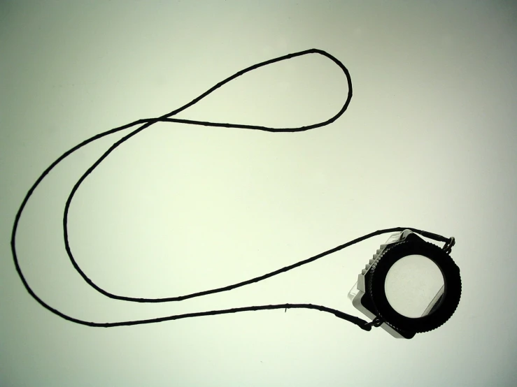 a black and white picture with a strap and a round object