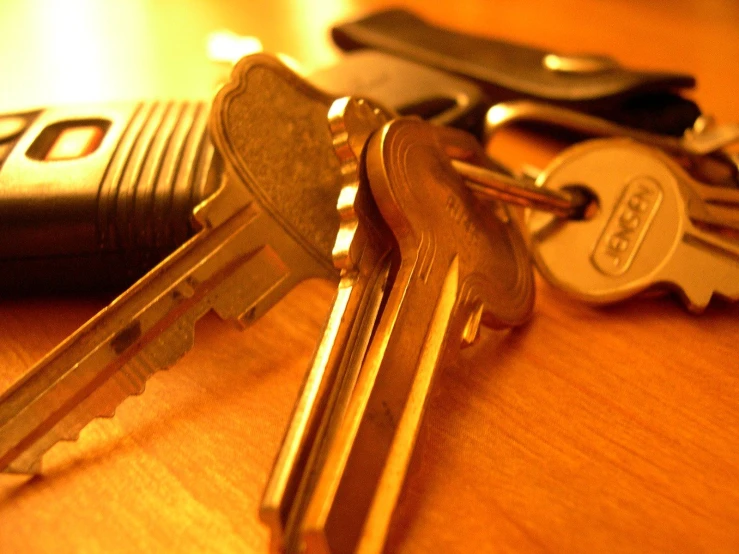 a set of keys on a table next to a remote control