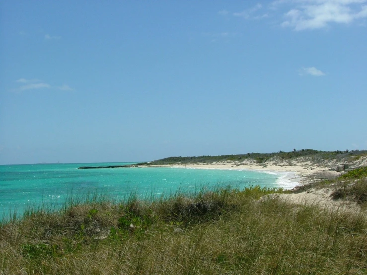 the water is blue and there are white sand on the beach