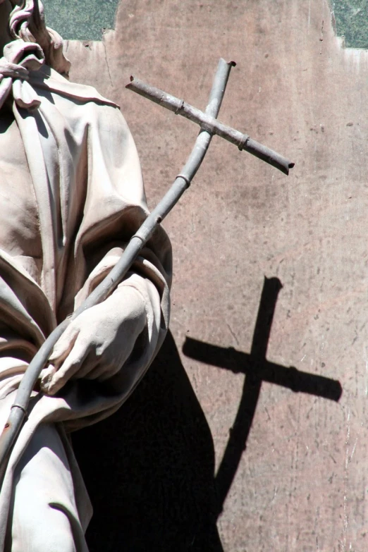 a white cross placed next to a stone wall