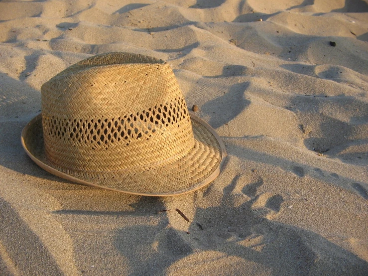 a hat sitting on top of a sandy beach