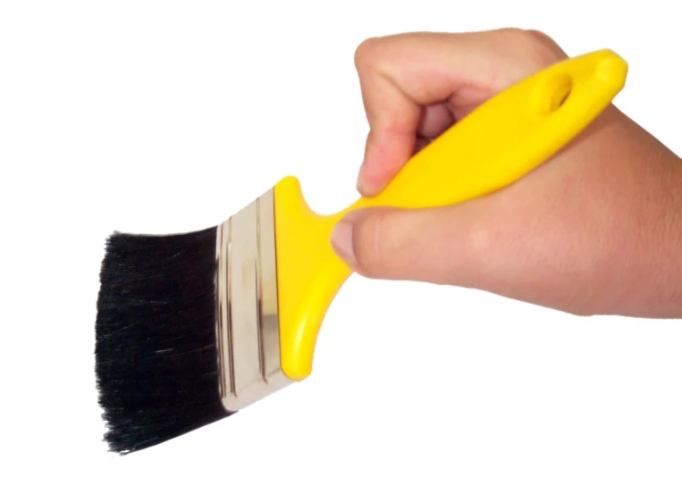 a person holds a paintbrush in their left hand