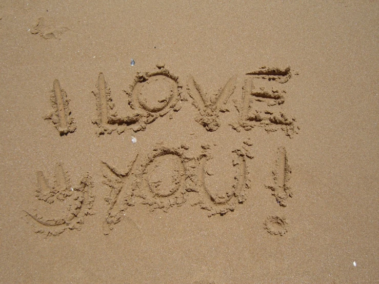 the words love you written in sand with the bottom half