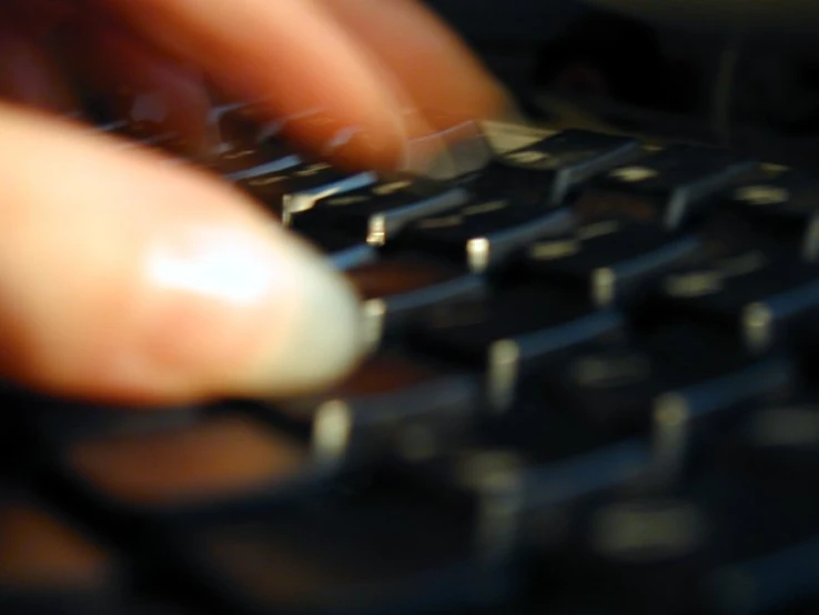 a hand presses the keys on a computer keyboard