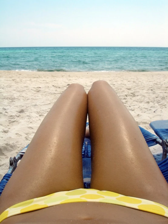 view of a person laying down on a beach towel looking at the ocean