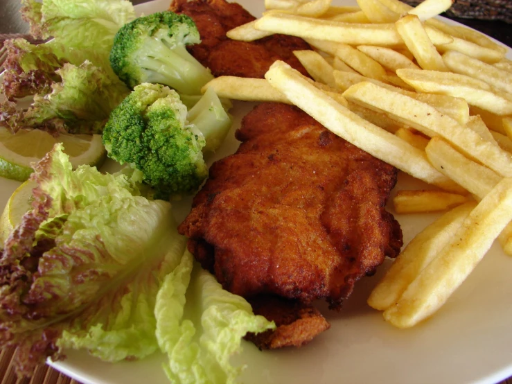 a meal is served with fries and broccoli