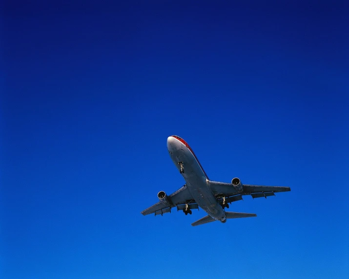 an airplane flies in a clear blue sky