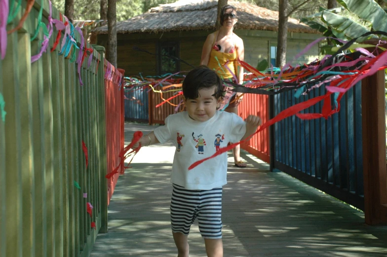 a child holding a kite on a wooden walkway