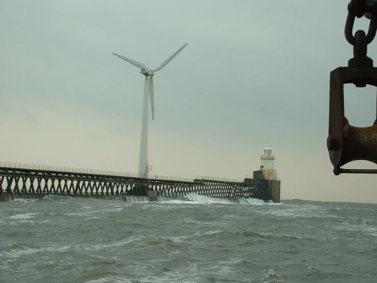 some large windmills in the ocean and a boat