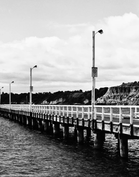 a pier extending into a body of water next to an inlet
